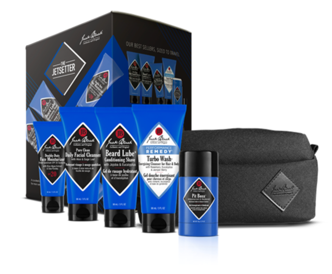Introducing The Jetsetter by Jack Black: a men’s grooming kit featuring five blue-and-black skincare essentials—including Beard Lube Conditioning Shave and Face Moisturizer SPF 20—packaged with a dark gray toiletry bag. Designed for on-the-go maintenance, this Travel Grooming Kit keeps your routine streamlined wherever you are. The background packaging is labeled “Jetsetter.”.