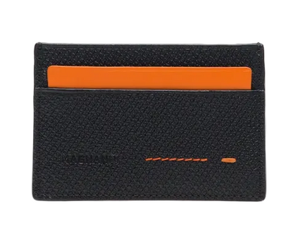 The Magnanni Card Holder is a black textured wallet featuring two card slots, with an orange card partially visible in the top slot. This lightweight accessory offers sleek organization for your essentials.