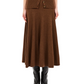 A person wearing the Ulla Johnson Azaria Knit Skirt in brown merino wool, styled with a coordinating buttoned top and black knee-high boots, shown from shoulders down.