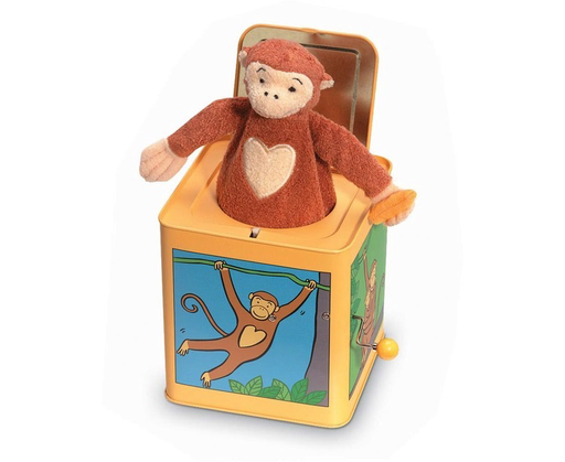 A brown plush monkey surprises from a yellow Jack-in-the-Box by Jack Rabbit Creations, which is adorned with playful cartoon monkey images, adding whimsical charm for fans of plush characters.