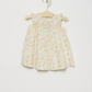 Bonpoint Baby Girls' and Girls' Narni Blouse with Cherry Print, sleeveless with ruffle sleeves, crafted from white organic cotton, shown on a wooden hanger against a plain white background.