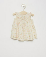 Bonpoint Baby Girls' and Girls' Narni Blouse with Cherry Print, sleeveless with ruffle sleeves, crafted from white organic cotton, shown on a wooden hanger against a plain white background.