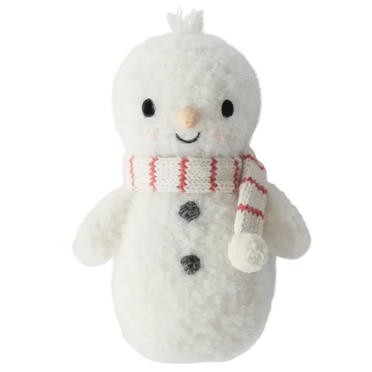The Baby Snowman - Candy Cane by Cuddle + Kind is a plush toy handcrafted from soft baby companion cotton yarn, featuring stitched black eyes, a smiling mouth, a carrot-shaped nose, black buttons, and a white scarf with red stripes for heirloom-quality charm.