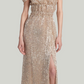 A woman models the Altuzarra Lily Dress, featuring sequins, an off-the-shoulder neckline, ruffled top, cinched waist, and thigh-high slit, set against a plain light background.