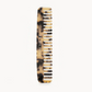 The Machete Comb No. 3, a tortoiseshell-patterned wide-tooth comb made from Italian bio-acetate and engraved with the brand name, is displayed against a plain white background.