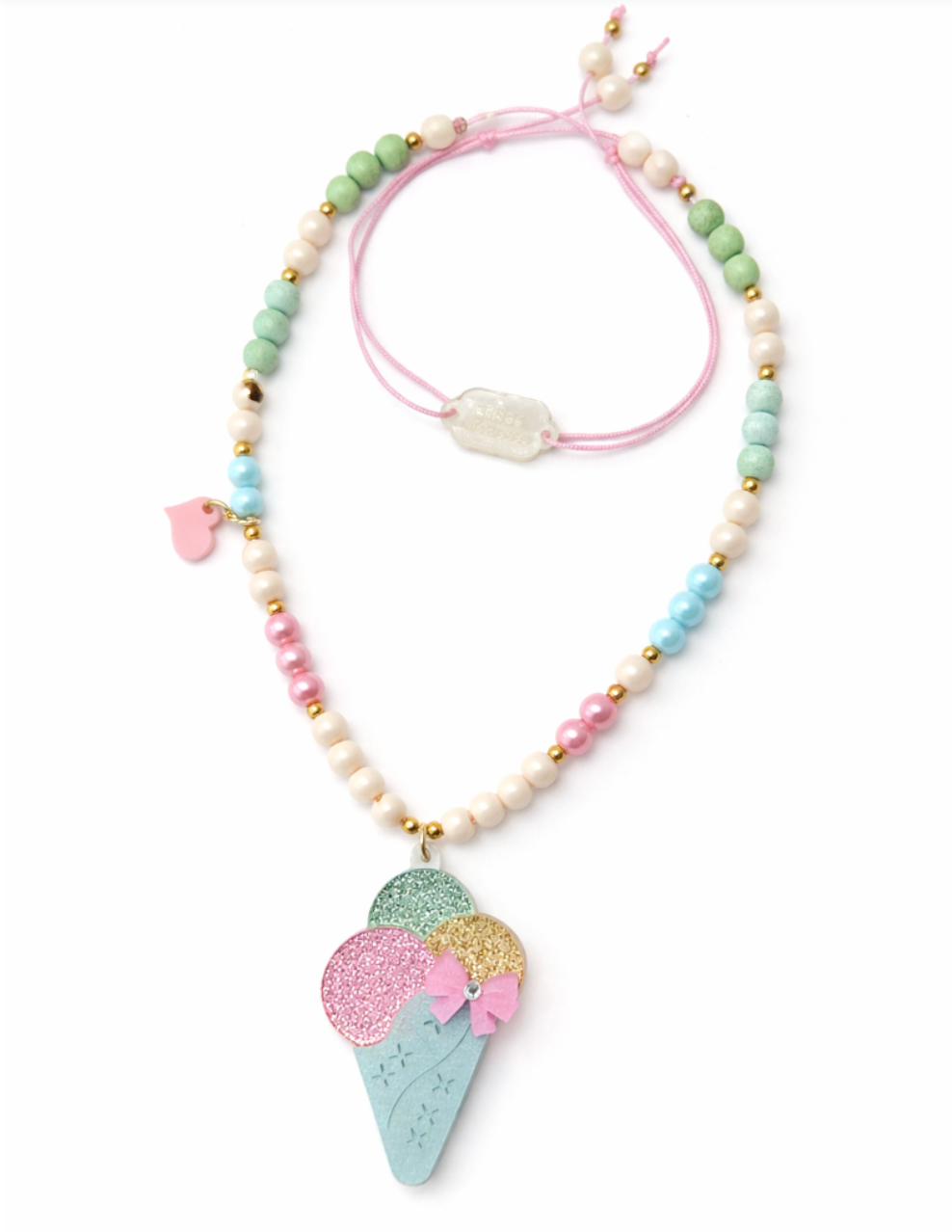 Add a sprinkle of sweetness to your look with the Lillies & Roses Ice Cream Cone Glitter Pastel Necklace—a charming accessory featuring pastel beads and a playful glitter ice cream cone pendant, perfect for brightening up any summer outfit.