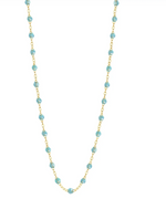 The Gigi Clozeau Classic Gigi Necklace 19.7", fashioned in 18-carat yellow gold, showcases a fine gold chain accented by small turquoise beads evenly distributed along its length, capturing the timeless elegance associated with Gigi Clozeau.