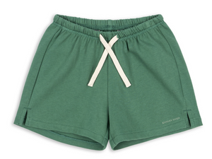 The Konges Slojd Baby Boys’ and Boys’ Spotty Sweat Short in green features a soft fabric, elastic waistband with adjustable drawstring, and small side slits, displayed on a white background.