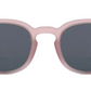 Front view of IZIPIZI Kids’ #C Polarized Sunglasses, showing matte light pink frames and dark lenses with an ergonomic design for comfort and reliable UV protection, displayed on a white background.