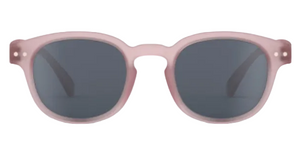 Front view of IZIPIZI Kids’ #C Polarized Sunglasses, showing matte light pink frames and dark lenses with an ergonomic design for comfort and reliable UV protection, displayed on a white background.