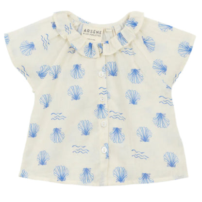 The Arsene & Les Pipelettes Baby Girls' Felixia Top is a white short-sleeve blouse with a blue shell and wave print, ruffled collar, and front buttons.