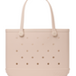 Beige rubber Original Bogg® Bag tote featuring two handles, a rectangular silhouette, and small evenly spaced holes on the front and sides. The Bogg Bags brand name is embossed near the bottom edge, making this tote a durable and conveniently washable beach bag.