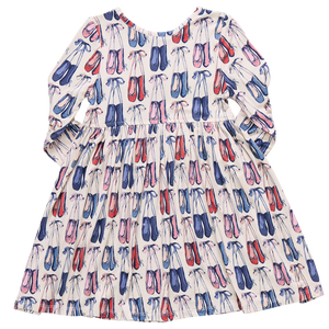 The Pink Chicken Girls' Bamboo Steph Dress is a long-sleeved dress made from soft bamboo, featuring a pink and blue ballet shoe pattern on a white background.