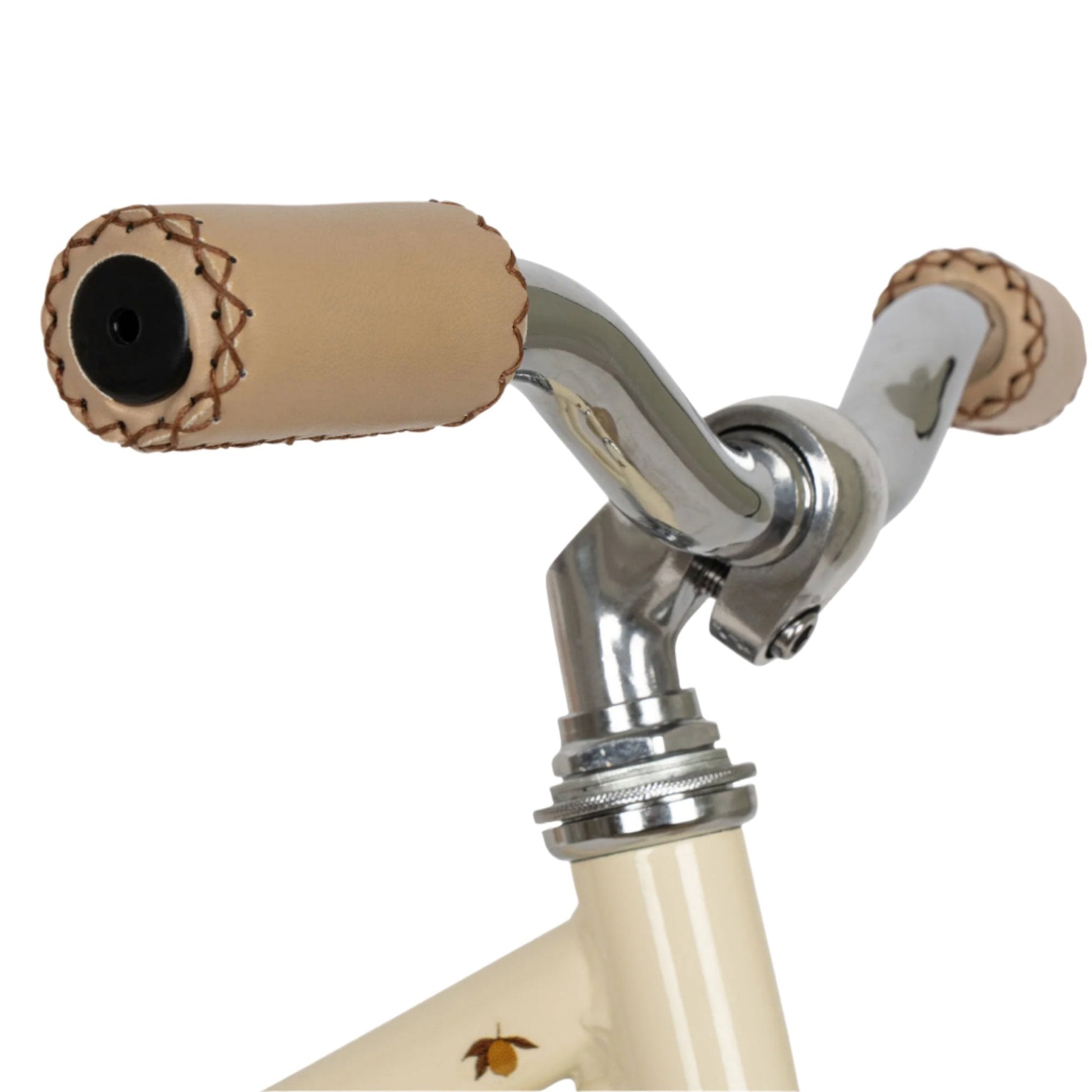 Close-up of the Konges Slojd Balance Bike handlebar with beige leather grips showing detailed stitching, attached to a cream-colored lightweight design by Konges Slojd.