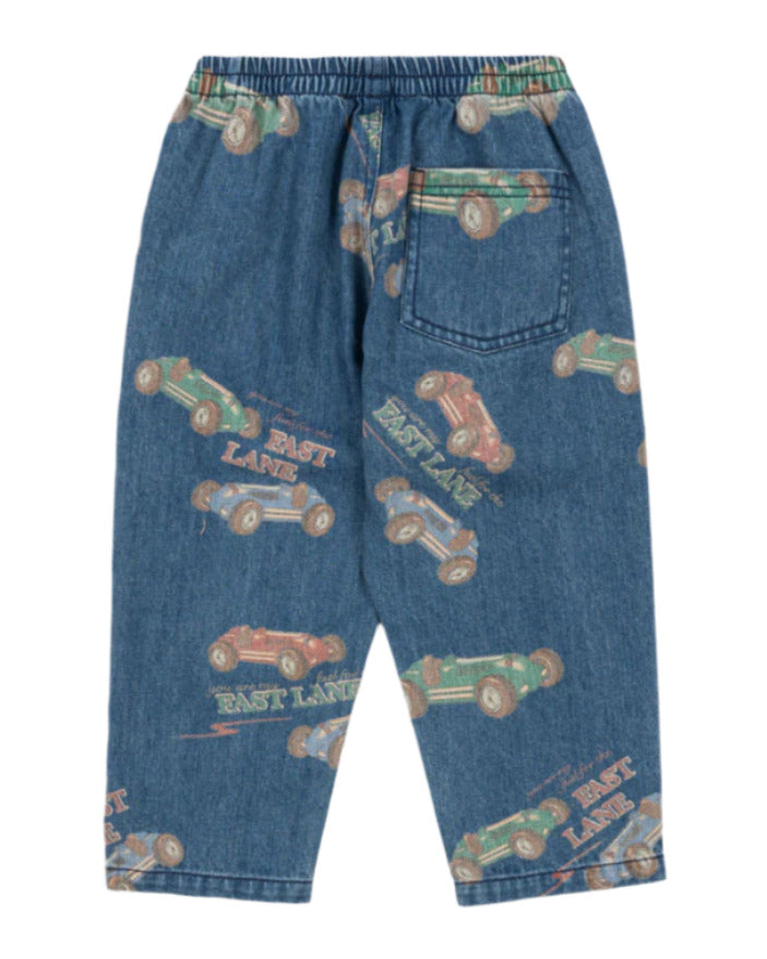 The Konges Slojd Baby Boys' and Boys' Magot Pants feature a blue denim straight fit, elastic waist, back pocket, and an all-over vintage race car print with the words "EAST LANE.