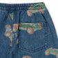 Close-up of Konges Slojd Baby Boys' and Boys' Magot Pants in blue denim with a straight fit, elastic waist, back pocket, and a colorful vintage race car print.