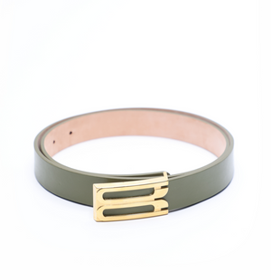 The Victoria Beckham Regular Frame Belt, crafted from green calf leather with a gold rectangular buckle, is shown coiled on a white background to showcase its elegant gold hardware.