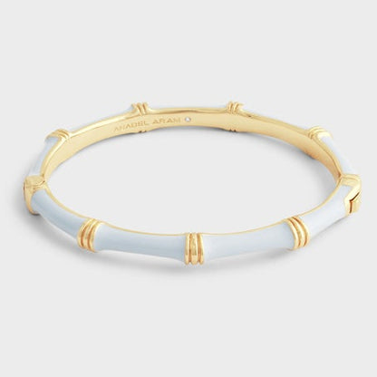 The Anabel Aram Bamboo Hinged Bangle features a sculpted gold and white bamboo design, shown against a plain light gray background.