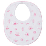The Kissy Kissy Ready to Dance Bib is made from soft Pima cotton with a pink trim, decorated with prints of dresses, purses, and flowers. It features a button closure at the neck—perfect for keeping mealtime messes away.