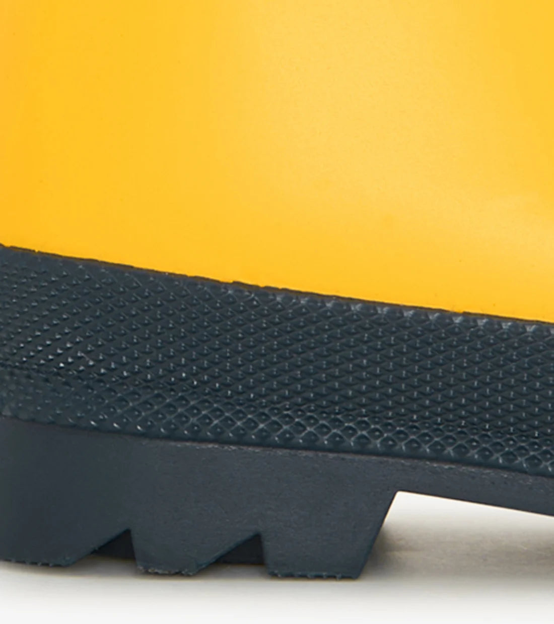 Close-up of the lower part of the Hatley Yellow & Navy Matte Rain Boots, featuring a slip-resistant rubber sole with a visible tread pattern, highlighting their durability as waterproof kids’ footwear.