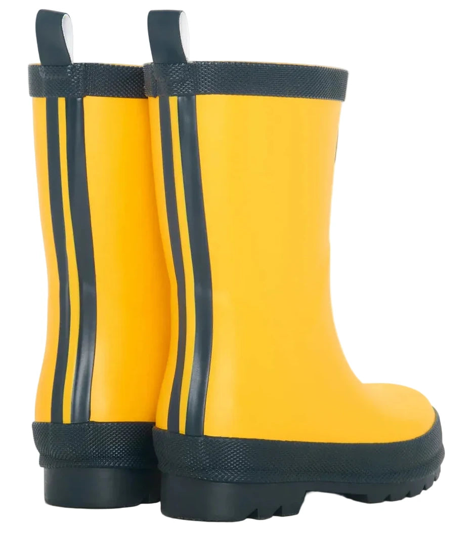 A pair of Hatley Yellow & Navy Matte Rain Boots for kids, featuring yellow uppers with black soles and two vertical black stripes on the back, shown from the rear. These waterproof boots are made with slip-resistant rubber to help ensure safety in wet conditions.