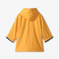 The Hatley Kids’ Yellow Zip Up Splash Jacket is displayed from the back, showcasing long sleeves with dark blue cuffs and a small white patch on the left sleeve. This PVC-free raincoat provides dependable splash protection, making it ideal for rainy days.