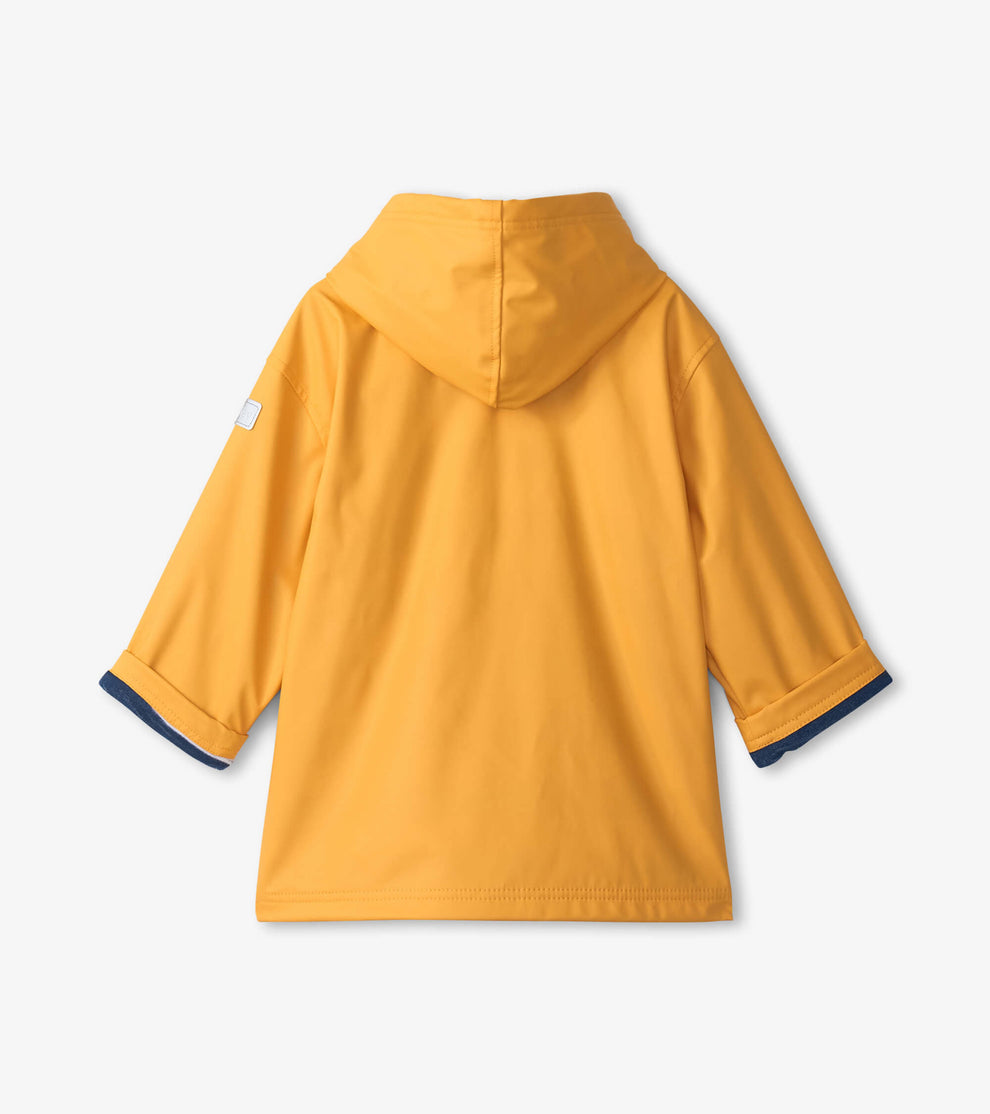 The Hatley Kids’ Yellow Zip Up Splash Jacket is displayed from the back, showcasing long sleeves with dark blue cuffs and a small white patch on the left sleeve. This PVC-free raincoat provides dependable splash protection, making it ideal for rainy days.