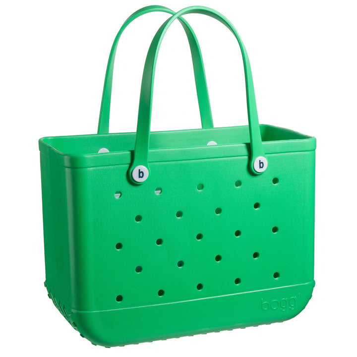 The Original Bogg Bag by Bogg Bags is a green, rectangular beach bag with two handles and small round holes on all sides, designed to stand upright for durability.