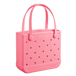 The Baby Bogg Bag by Bogg Bags is a pink, washable tote with two handles, made of perforated rubber-like material. Shown on a plain white background, this stylish and practical bag is perfect for everyday use.