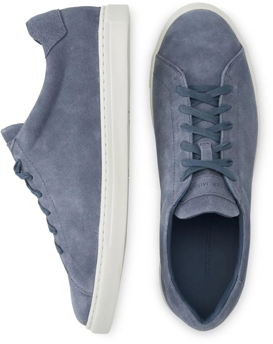 The Peter Millar Vantage Lite Suede Sneaker, shown in blue with a comfort-enhancing suede upper and white rubber soles, is featured from the side and top view against a white background.