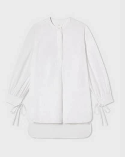 The CO Cuff Tie Shirt features long sleeves, a round neckline, henley placket, gathered cuffs, and ribbon ties at the wrists, shown laid flat on a light background.