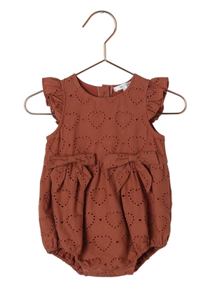 The Noralee Baby Girls' Betsy Romper, featuring heart eyelets, ruffle cap sleeves, two front bows, a bubble shape, and snap closures, is shown hanging against a white background.