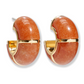Lizzie Fortunato's Zellige Hoops feature gold-trimmed, rounded orange stones with a glossy finish, handcrafted to reflect the elegance of Moroccan Zellige tiles, shown on a white background.