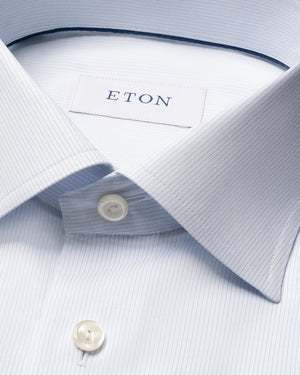 Close-up of the Eton Contemporary Striped Twill Shirt in light blue, featuring subtle stripes, a pointed collar, white buttons, and the signature Eton label inside the collar. Made from 100% cotton, this shirt combines comfort and refined elegance for any occasion.