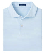 A folded light blue Chord Performance Jersey Polo by Peter Millar, with thin white stripes and a visible brand label inside the collar, offers four-way stretch for enhanced comfort and flexibility.