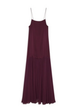 The Clementine Dress by Anine Bing is a sleeveless, dark purple satin dress with a modern silhouette, thin spaghetti straps, and a flowy, pleated skirt, shown against a white background.