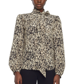 A person wears the Joan Top by Adam Lippes, an Italian silk long-sleeve leopard print blouse with neck tie detail, paired with black pants.