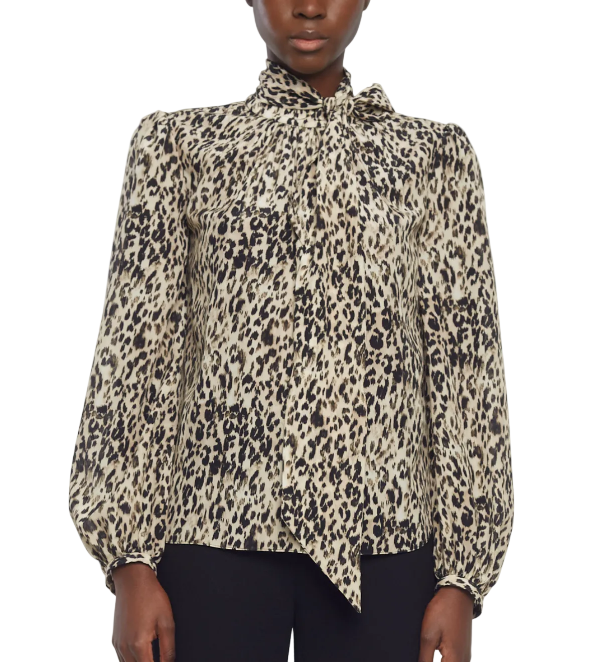 A person wears the Joan Top by Adam Lippes, an Italian silk long-sleeve leopard print blouse with neck tie detail, paired with black pants.