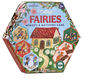 Eeboo’s Cottage Fairies Memory & Matching Game comes in a hexagonal box designed for ages 3 and up, adorned with enchanting fairy illustrations, whimsical animals, and a delightful forest cottage. The packaging features eco-friendly and recycled content labels along with exquisite gold foil accents that add a magical touch.