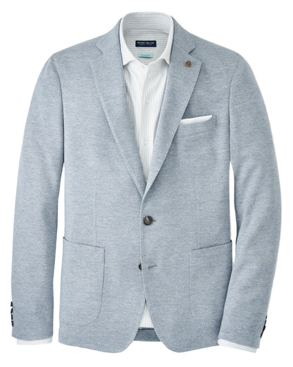 The Peter Millar Barclay Knit Soft Jacket in light gray-blue features a relaxed fit, two front pockets, a chest pocket with white pocket square, dark buttons, and is styled over a white collared shirt.