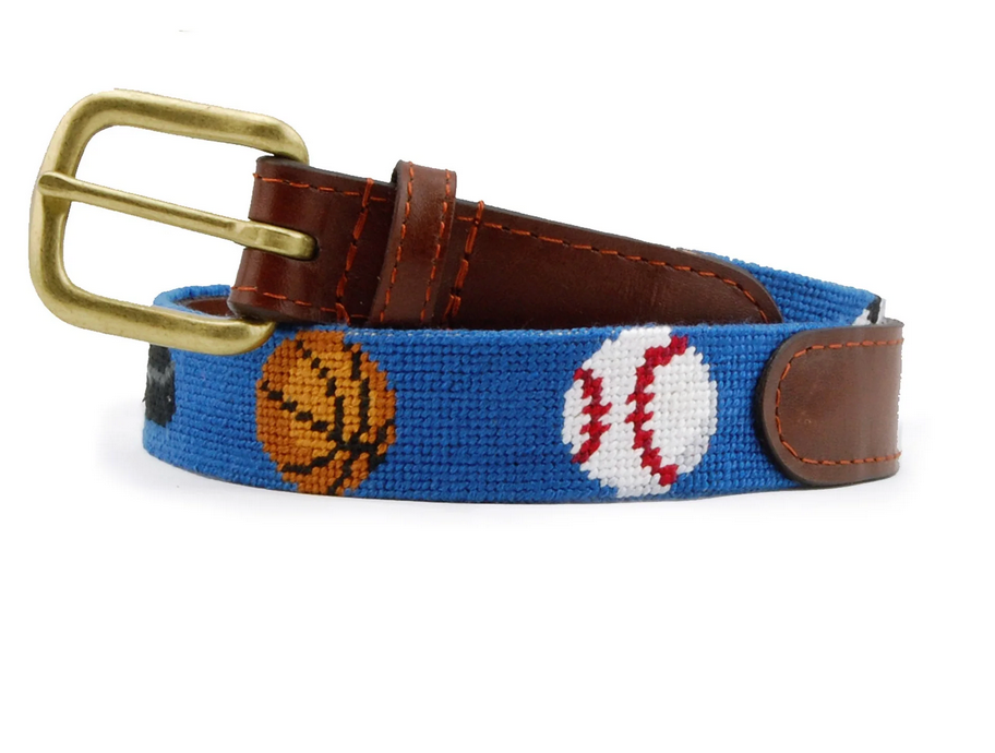 The SMB Children's Sports Belt by Smathers & Branson features a blue design with hand-stitched needlepoint images of a basketball and baseball, accented with brown Italian leather and a shiny gold buckle.