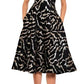 A woman is wearing a Prabal Gurung V Neck Fit & Flare Dress in black, showcasing a breathtaking silver abstract pattern with metallic gold accents, paired flawlessly with black high-heeled sandals.