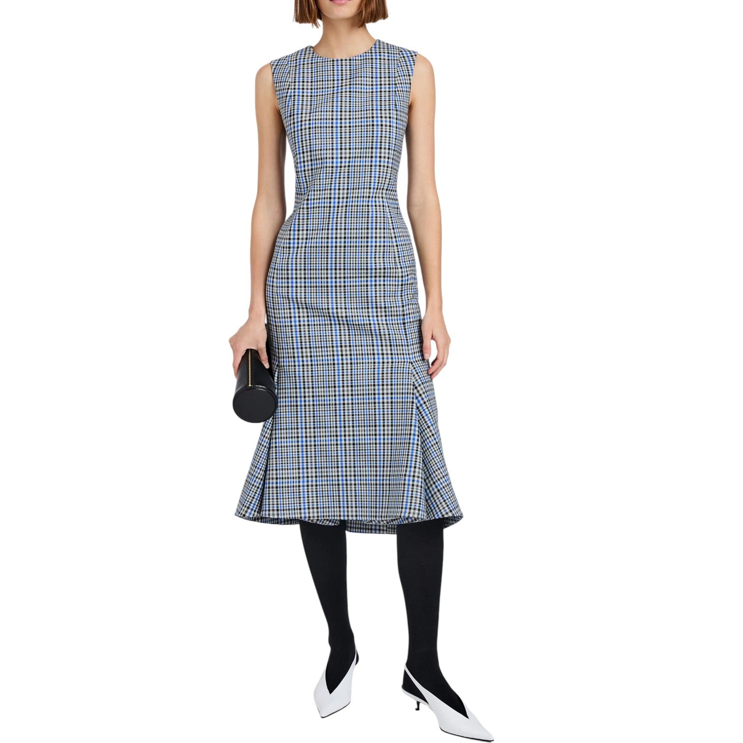 A woman wears the Proenza Schouler Bruna Plaid Wool Nylon Dress—sleeveless and blue-and-white, styled with black tights, white heels, and a black cylindrical clutch against a white background.
