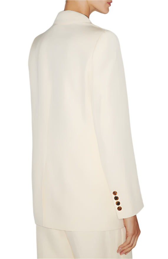 Someone is seen from behind wearing the Blaze Milano Savannah Everyday Blazer, which is off-white, double-breasted, and features a classic collar along with buttoned cuffs.