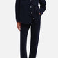A person wearing a dark button-up jacket with front pockets, paired with the Blaze Milano Clapotis Paso Jeans in a matching dark blue straight-leg style and black pointed-toe heels, stands with one hand in their pocket.