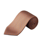 Eton’s Geometric Printed Silk Tie, featuring an orange base with a repeating geometric pattern in blue and white, is rolled up on a white background—a perfect accessory for introducing business sophistication to any ensemble.