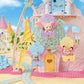 Three adorable small animal figurines from the Calico Critters brand sit in pastel balloon-shaped seats on the whimsical Ferris wheel of the Baby Dream Amusement Park playset, surrounded by a charming castle toy and creating a magical miniature fantasy-themed scene.