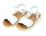 The Girls' Ella Scalloped Sandals by L'Amour Shoes feature white scalloped edges, ankle straps, and tan insoles, radiating a cheerful touch against a white background.