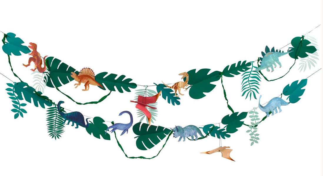 A large Meri Meri Dinosaur Kingdom Large Garland featuring various dinosaur cutouts and lush green foliage hangs against a white background, perfect for transforming any space into a Dinosaur Kingdom party.