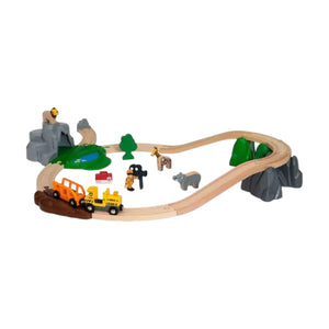The Brio Safari Adventure Set features a wooden train, tracks, vehicles, animal figures, trees, rocks, and a pond in an oval layout—perfect for inspiring safari fun.